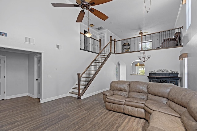 living area featuring visible vents, stairs, baseboards, and wood finished floors