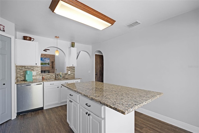 kitchen with visible vents, a kitchen island, dark wood-style flooring, stainless steel dishwasher, and a sink