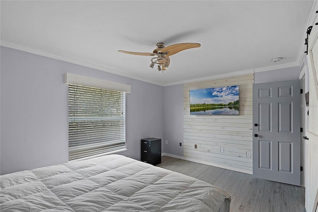 bedroom with ceiling fan, baseboards, wood finished floors, and ornamental molding