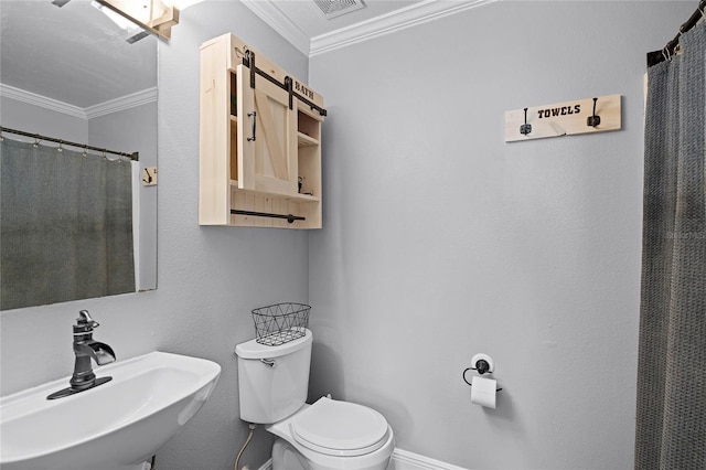 bathroom featuring crown molding, toilet, visible vents, and a sink