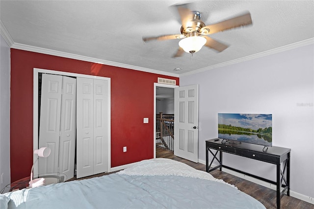 bedroom featuring visible vents, ornamental molding, a textured ceiling, wood finished floors, and a closet