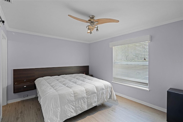 bedroom featuring ceiling fan, baseboards, wood finished floors, and crown molding