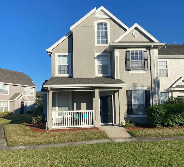 view of front of house with a porch, a front lawn, and stucco siding