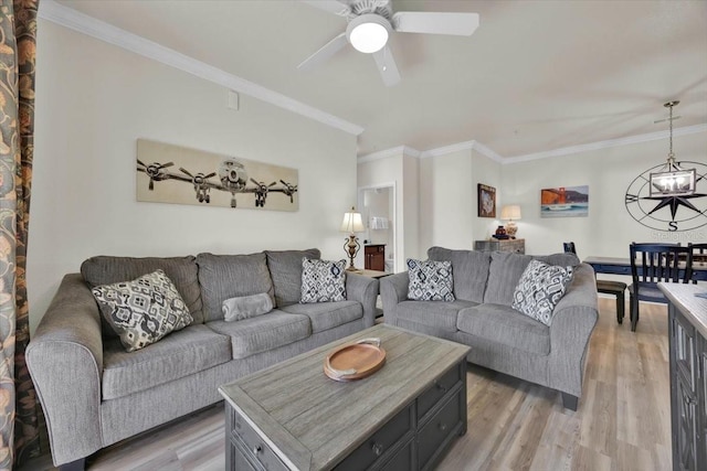 living area featuring light wood-style flooring, ceiling fan with notable chandelier, and crown molding