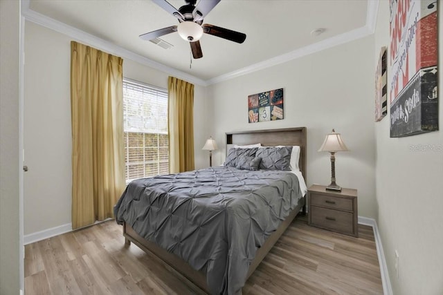 bedroom featuring visible vents, wood finished floors, baseboards, and ornamental molding