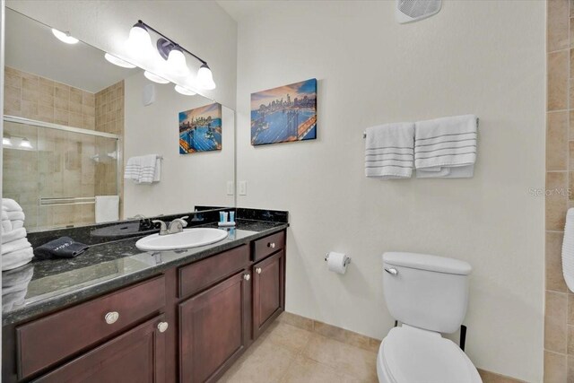 full bathroom featuring tile patterned floors, a stall shower, toilet, and vanity