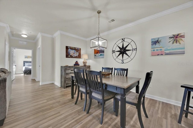 dining space with visible vents, crown molding, baseboards, and light wood-type flooring