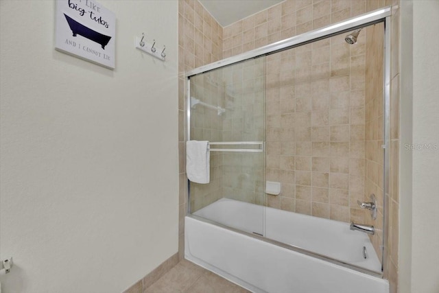 bathroom with tile patterned flooring, baseboards, and combined bath / shower with glass door