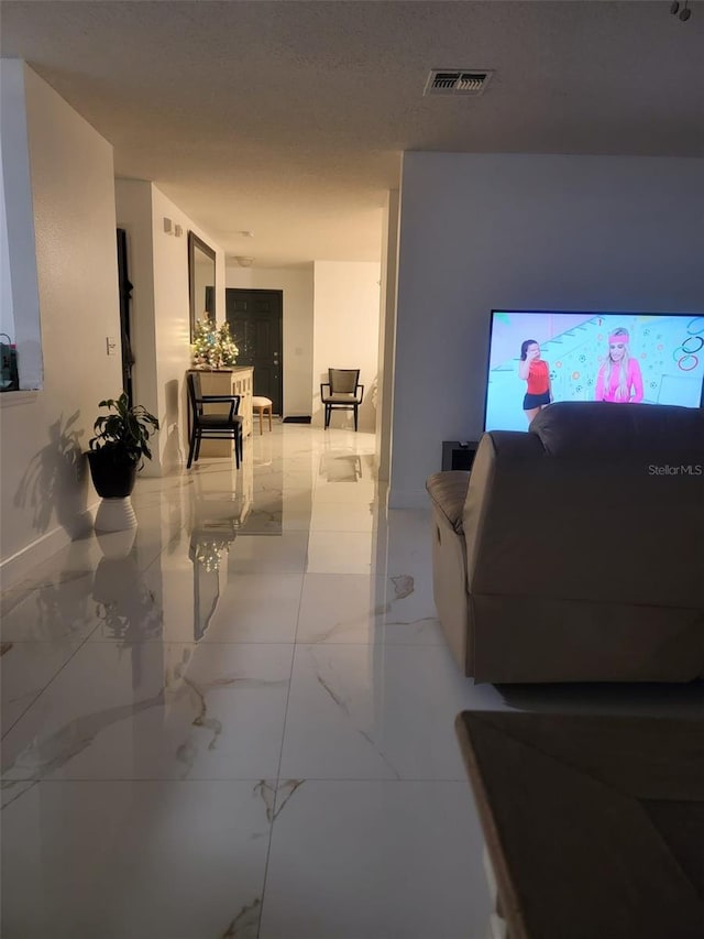 interior space featuring visible vents, a textured ceiling, and marble finish floor