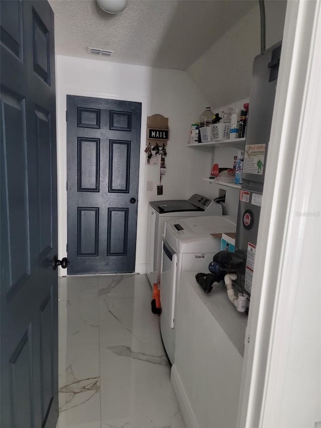 laundry area with visible vents, laundry area, a textured ceiling, washing machine and dryer, and marble finish floor