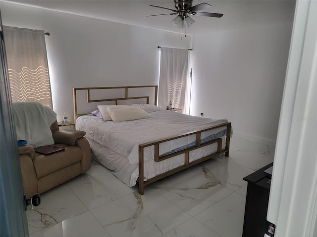 bedroom featuring a ceiling fan, marble finish floor, and baseboards