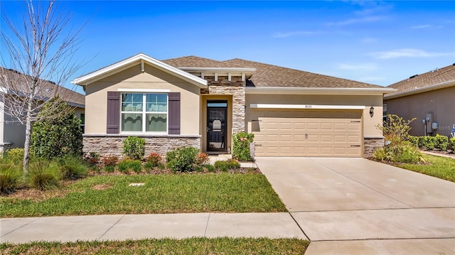 prairie-style house with stucco siding, stone siding, an attached garage, and driveway