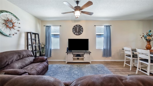 living room featuring plenty of natural light, a textured ceiling, ceiling fan, and wood finished floors