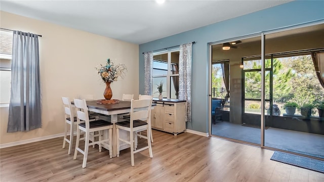 dining space with light wood finished floors, plenty of natural light, and baseboards