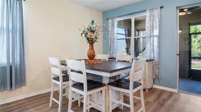 dining space featuring plenty of natural light, wood finished floors, and baseboards