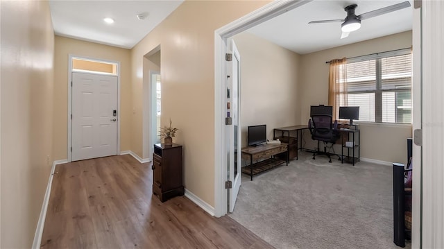 entrance foyer featuring wood finished floors, baseboards, carpet, and ceiling fan