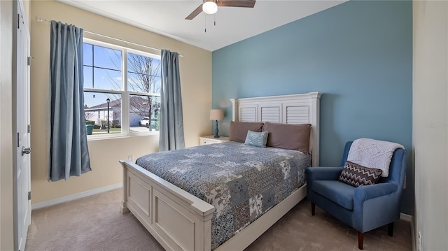 bedroom with light colored carpet, a ceiling fan, and baseboards