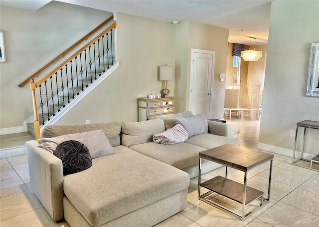 living room with light tile patterned floors, stairway, baseboards, and an inviting chandelier