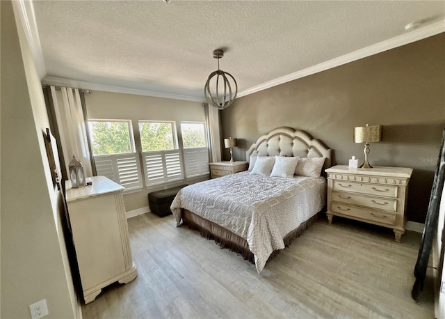 bedroom featuring a notable chandelier, ornamental molding, a textured ceiling, light wood-style floors, and baseboards