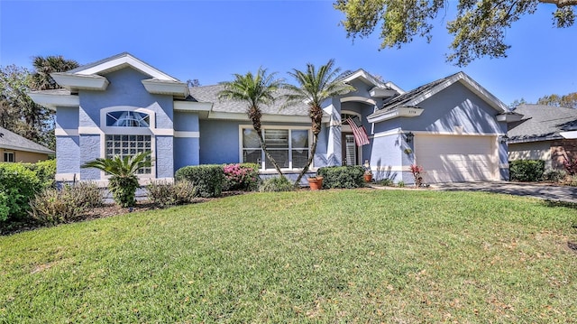 view of front of property with stucco siding, driveway, an attached garage, and a front lawn