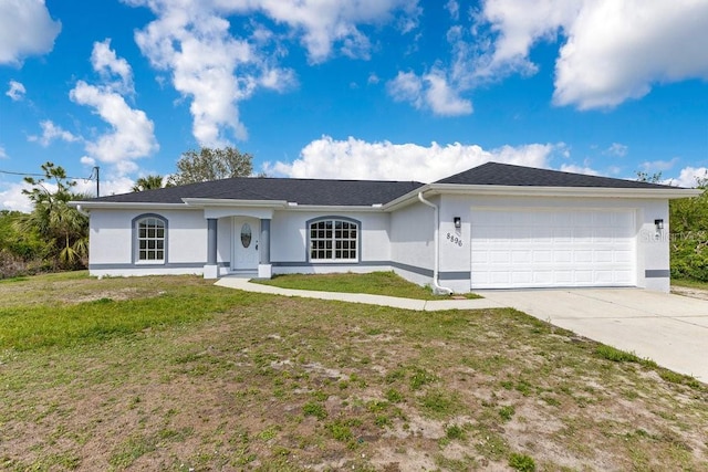 ranch-style house featuring concrete driveway, an attached garage, a front yard, and stucco siding