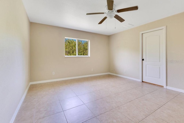 empty room featuring light tile patterned flooring, ceiling fan, and baseboards