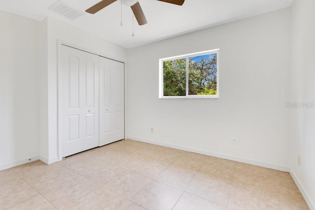 unfurnished bedroom featuring visible vents, baseboards, light tile patterned flooring, a closet, and a ceiling fan