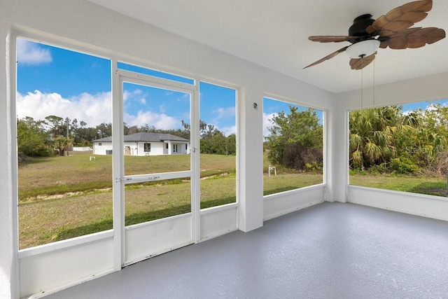 unfurnished sunroom featuring ceiling fan