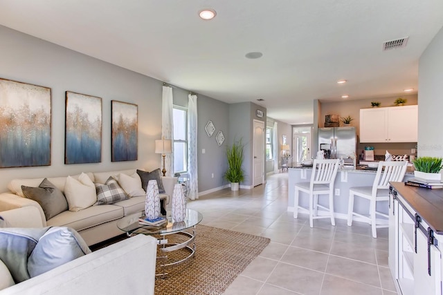 living room featuring light tile patterned floors, recessed lighting, visible vents, and baseboards