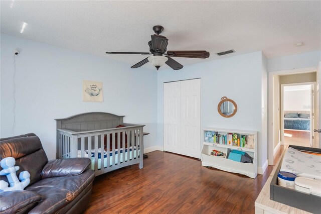 bedroom with wood finished floors, baseboards, visible vents, ceiling fan, and a closet