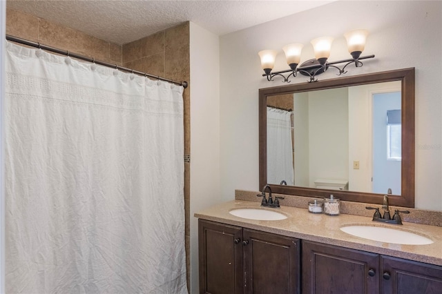 bathroom with double vanity, a textured ceiling, a shower with curtain, and a sink