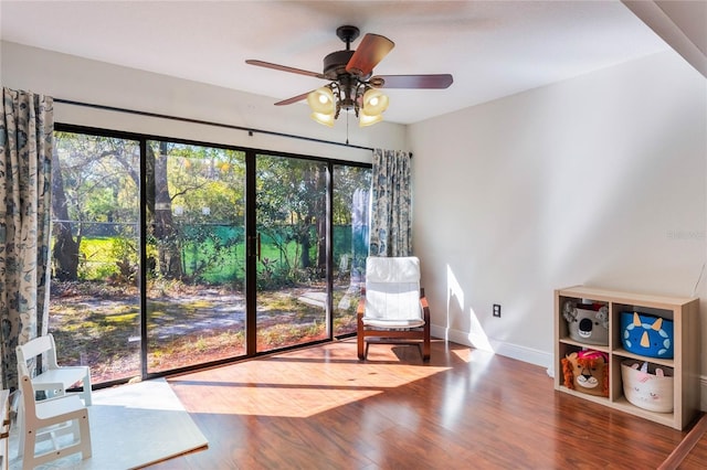 sitting room featuring a ceiling fan, wood finished floors, and baseboards