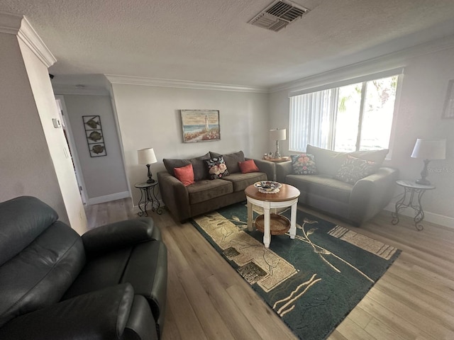 living area with crown molding, wood finished floors, visible vents, and a textured ceiling