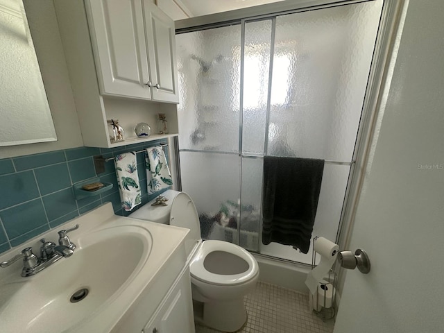 full bath with toilet, tile walls, a stall shower, and tile patterned flooring