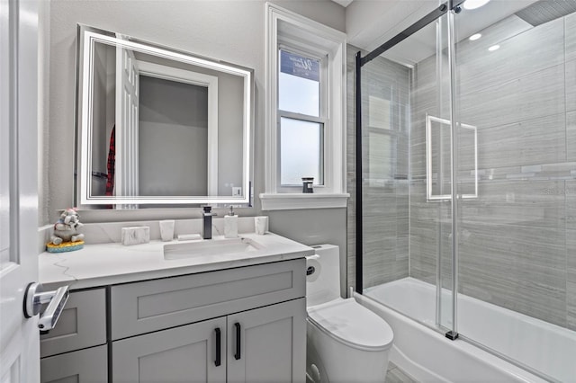 bathroom with enclosed tub / shower combo, toilet, and vanity