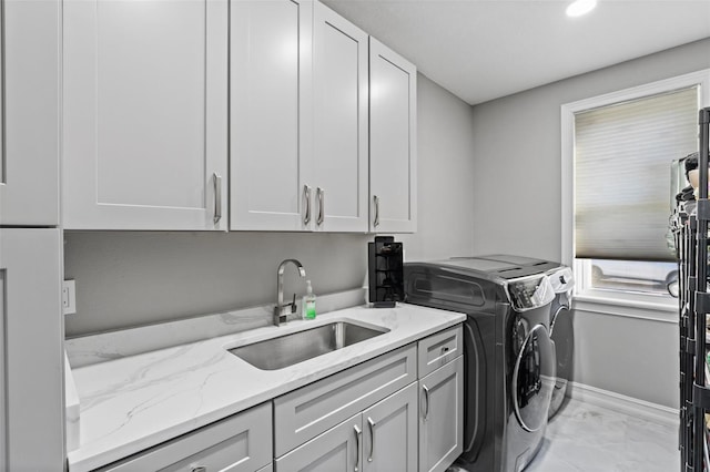 laundry area with marble finish floor, a sink, cabinet space, separate washer and dryer, and baseboards