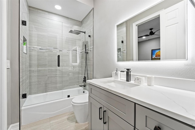 bathroom with vanity, toilet, and combined bath / shower with glass door