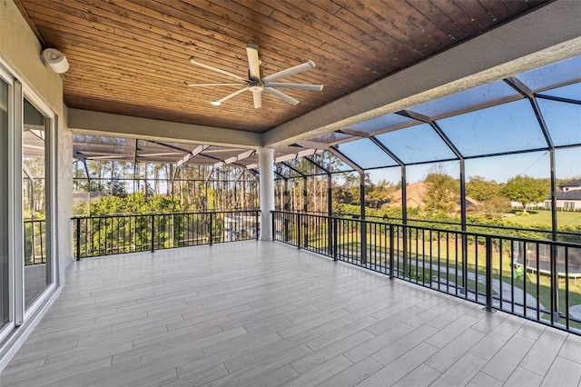 unfurnished sunroom with wood ceiling and ceiling fan