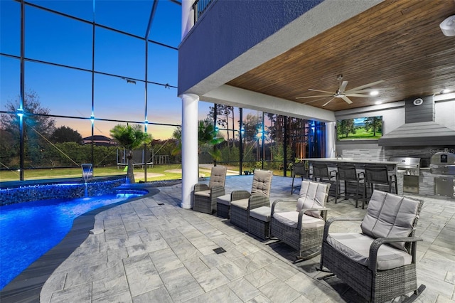 patio terrace at dusk featuring an outdoor pool, area for grilling, a lanai, and outdoor dry bar