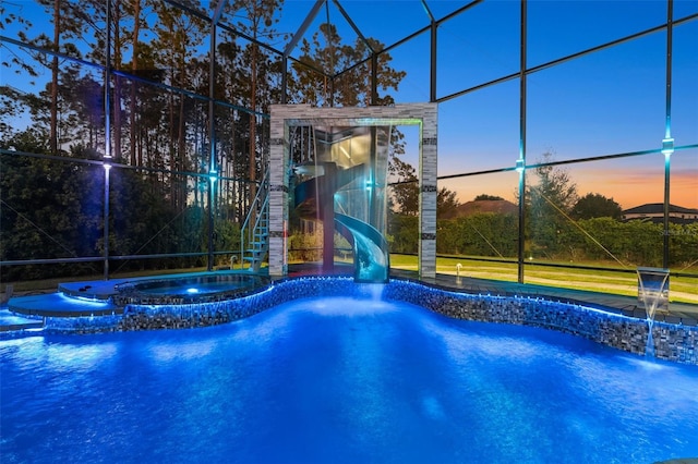 view of swimming pool featuring a lanai, a water slide, and a pool with connected hot tub