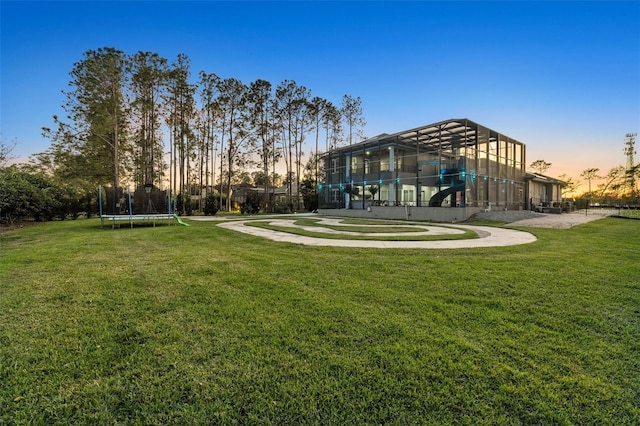 view of property's community featuring a trampoline and a lawn