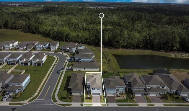 birds eye view of property featuring a forest view, a residential view, and a water view