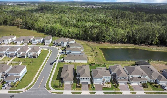 aerial view with a wooded view, a residential view, and a water view