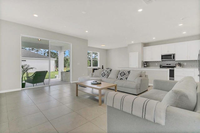 living room featuring light tile patterned floors, baseboards, and recessed lighting