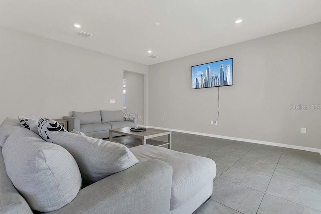 tiled living area featuring baseboards and recessed lighting
