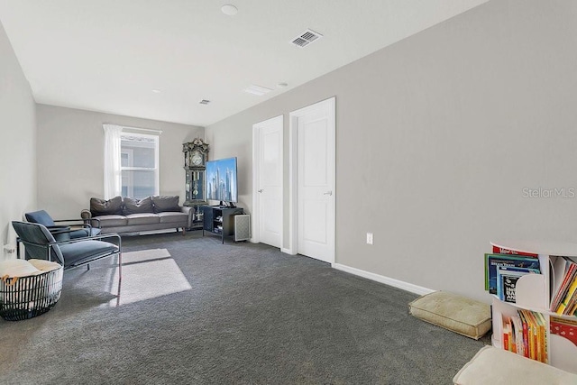 living area featuring dark colored carpet, visible vents, and baseboards