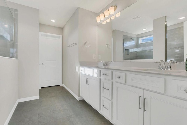 full bath with a sink, baseboards, and tiled shower