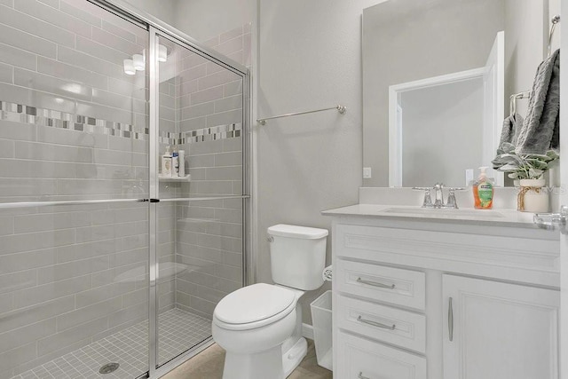 full bathroom featuring a shower stall, vanity, and toilet