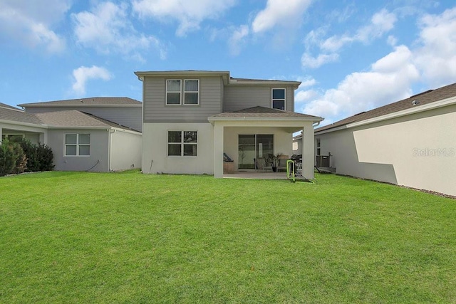 back of property featuring a patio, a yard, and stucco siding