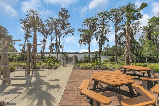 view of community with outdoor dining space, a patio area, and a gate